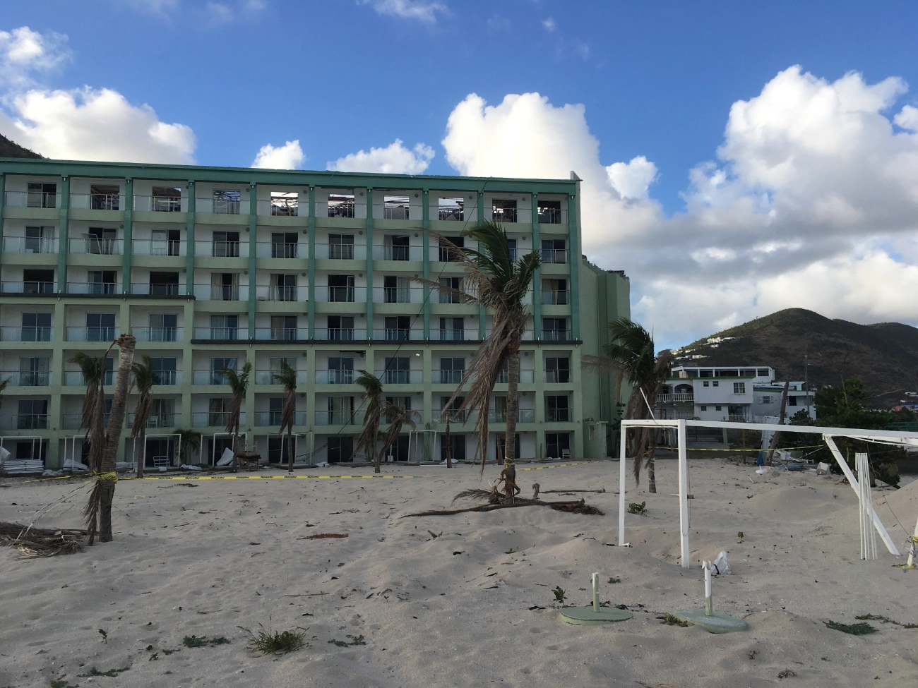 The empty beach in front of the building with damaged palms caused by the hurricane in Caribbean in 2017